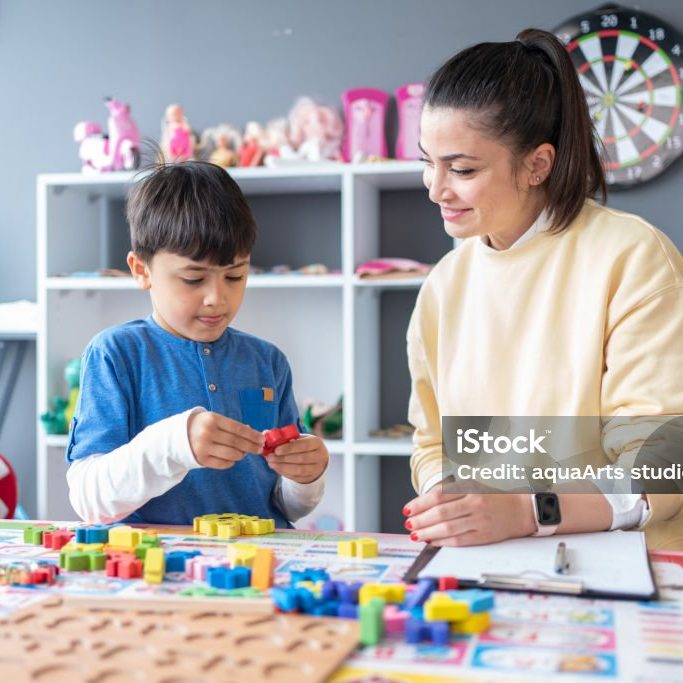 Professional Speech Therapist During A Session With Little Boy At Office
