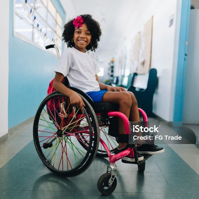Portrait of a girl student using wheelchair at school